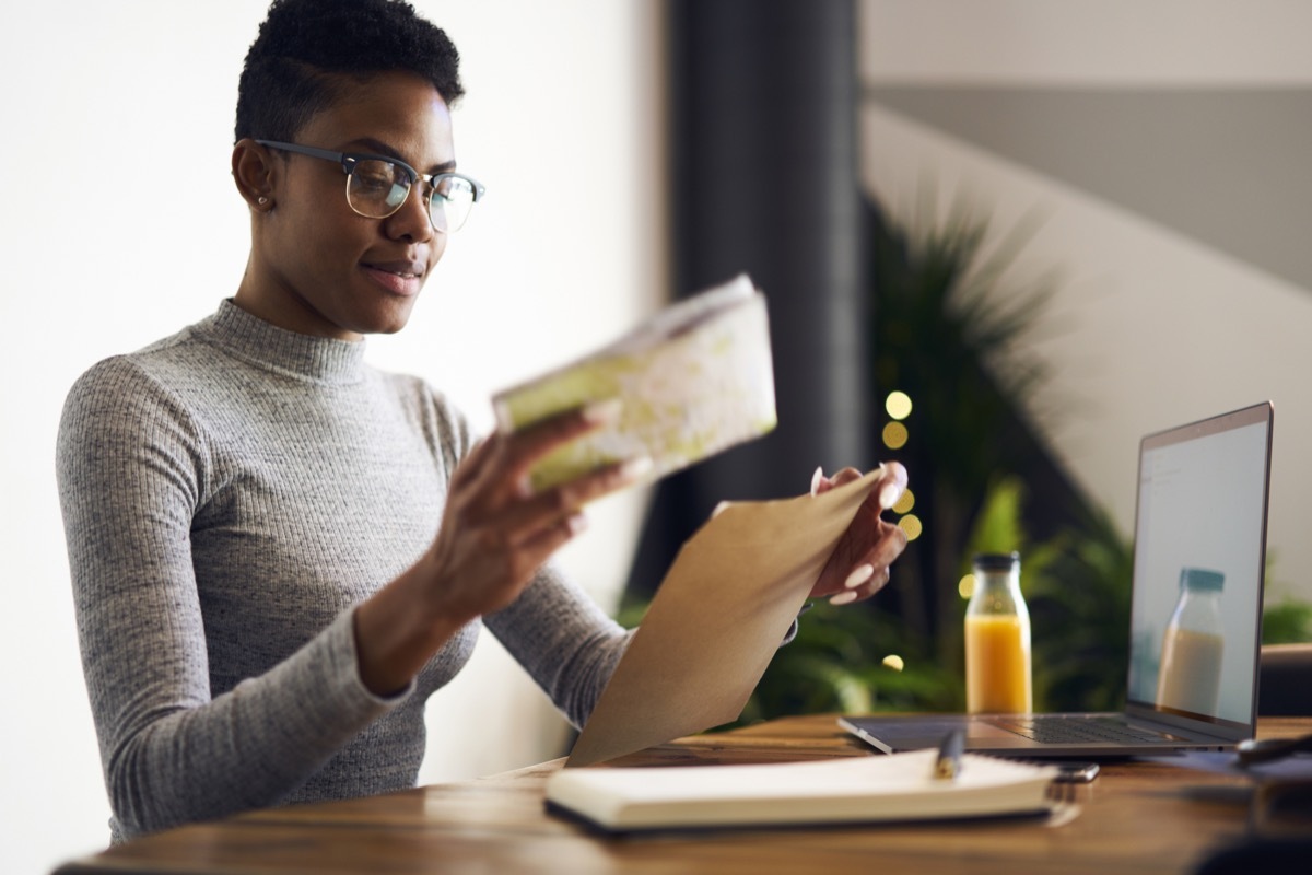 woman in glasses opening mail