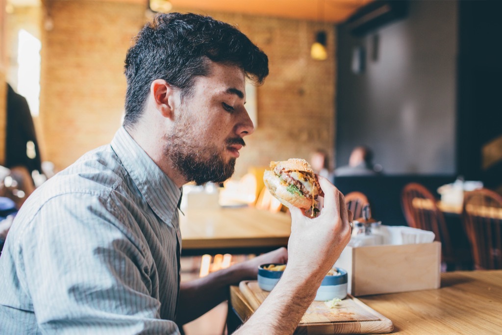 millennial eating burger ways we're unhealthy