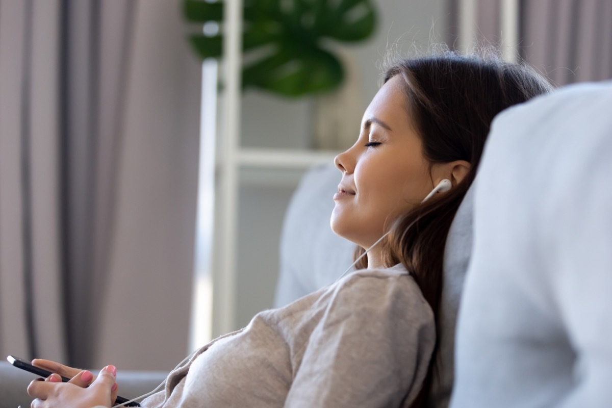 Woman meditating with earphones in