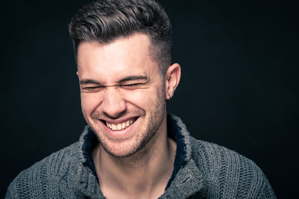 man laughing on black background bad jokes