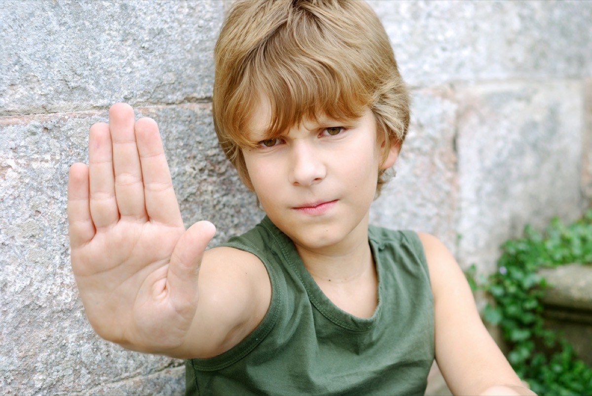 young boy putting hand up with palm out, bad parenting advice