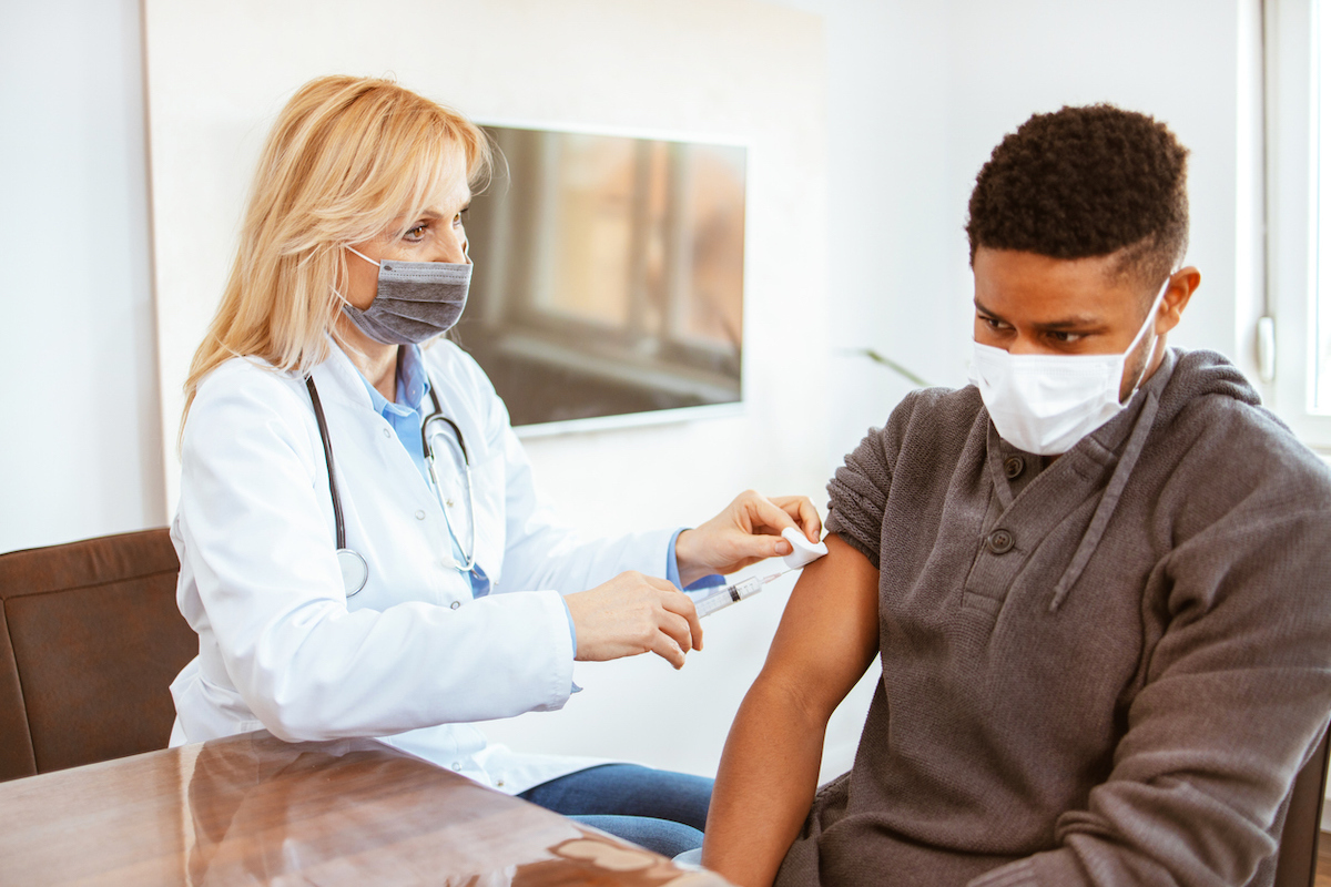 Man receives the COVID vaccine in a doctor's office at the hospital.