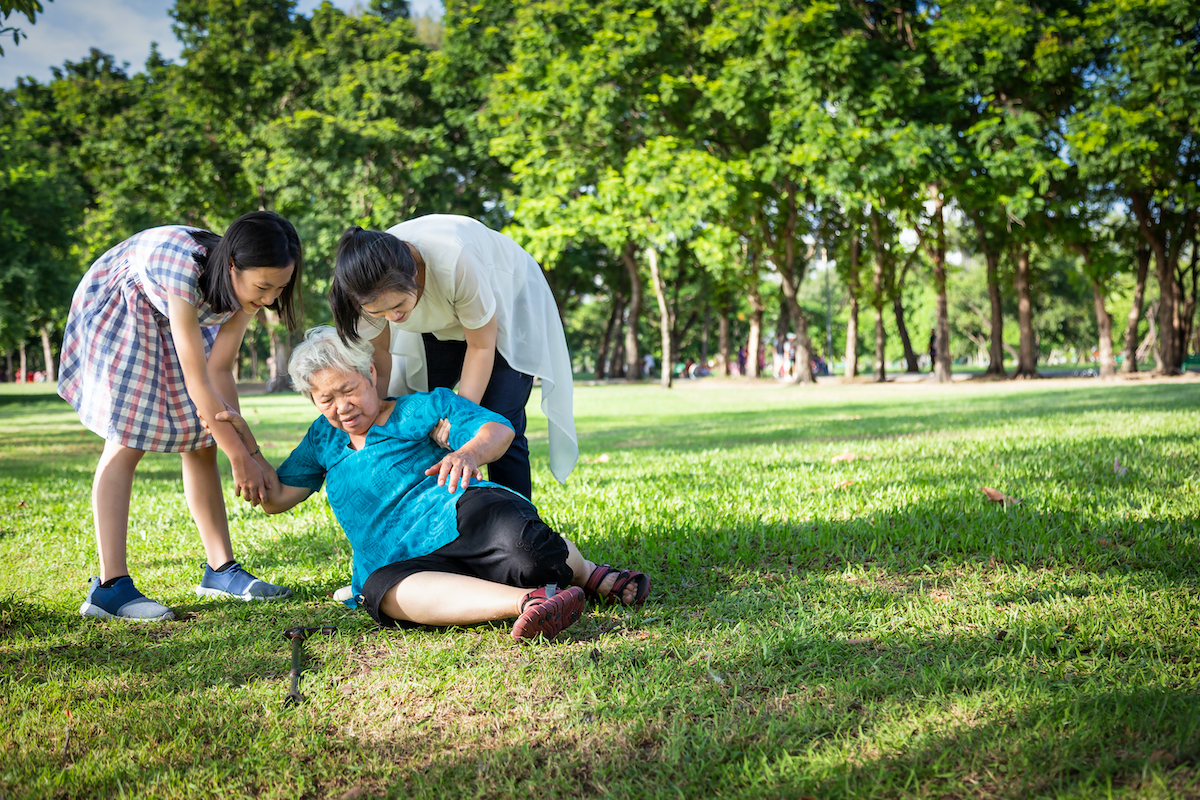 Elderly woman fallen, people helping