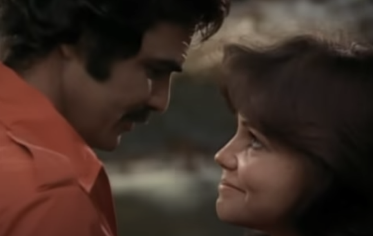 Burt Reynolds and Sally Field about to kiss in