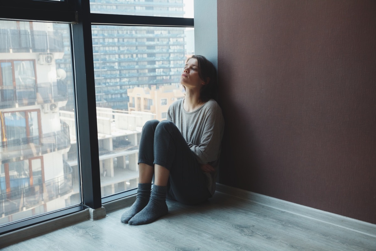 Woman on her floor looking upset.