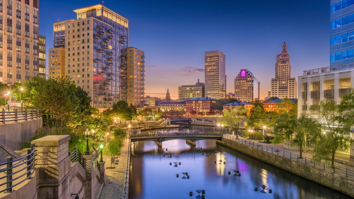 buildings and walking bridge by a lake in Providence, Rhode Island at night