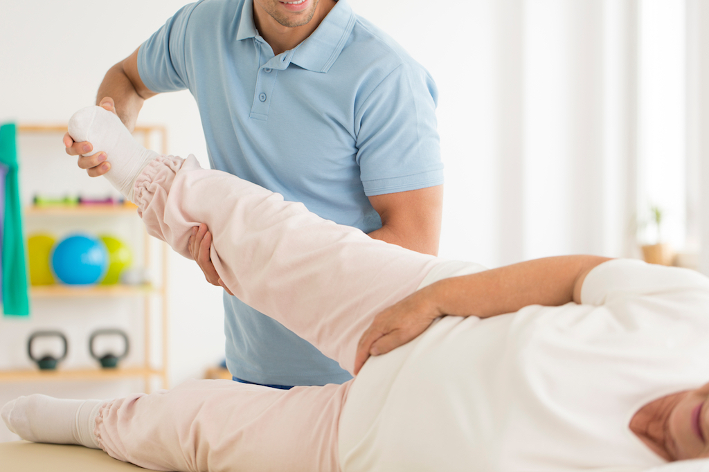 older woman getting her hip stretched out, most common injuries over 50
