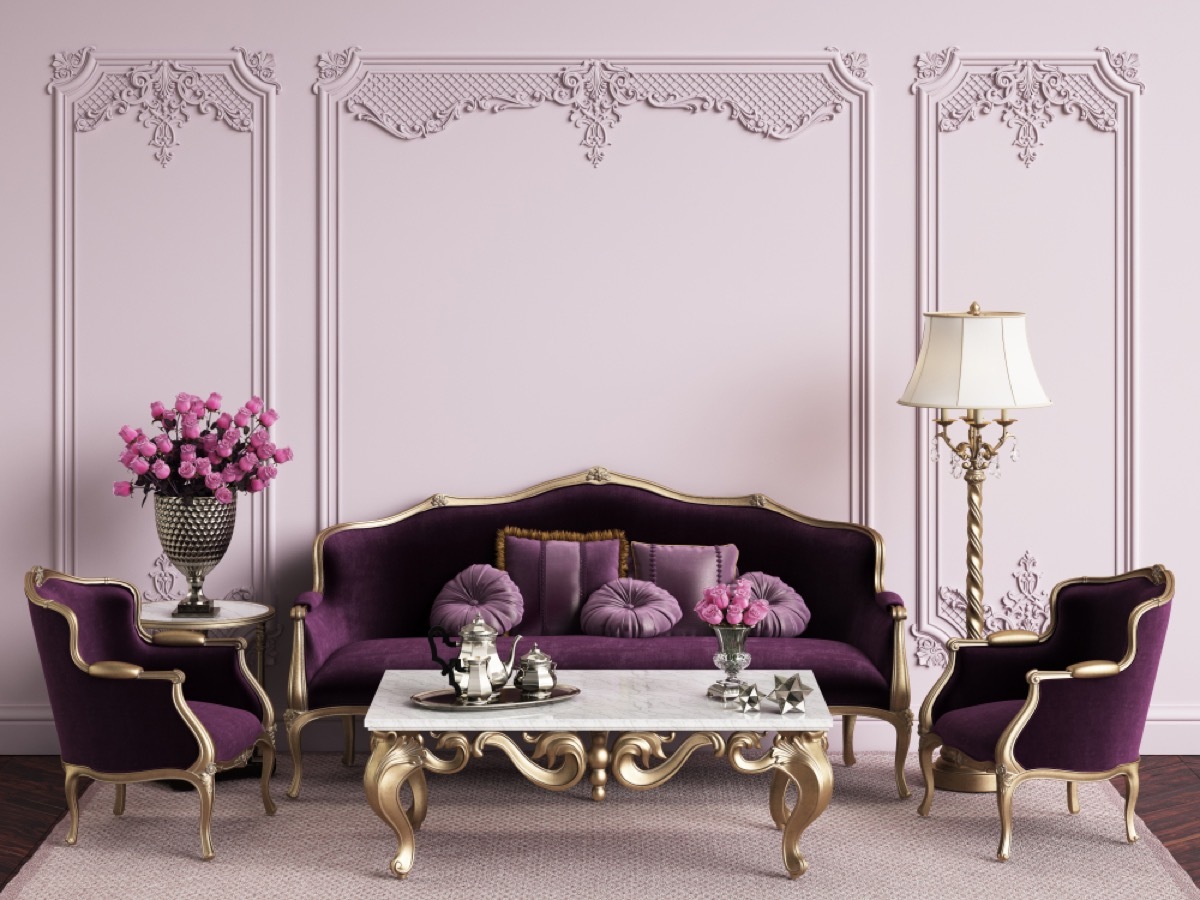purple living room with purple velvet couch and gold table