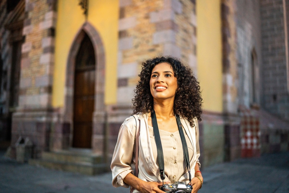 Young woman walking and looking around exploring the city