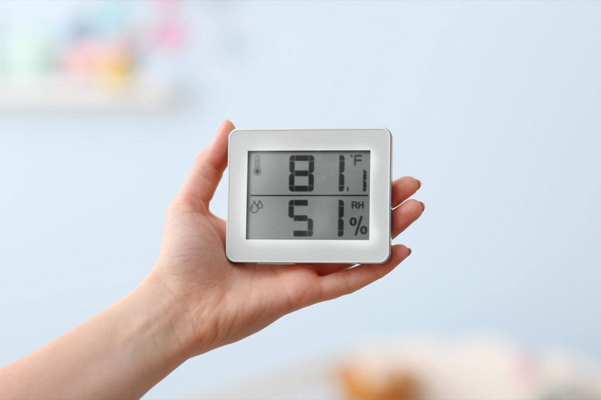 Woman checking temperature and humidity in baby room.