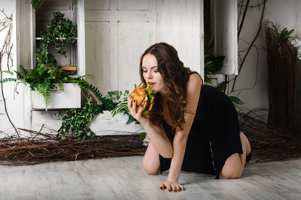 beautiful, sexy girl with a great burger. eats. Concept. weight loss.