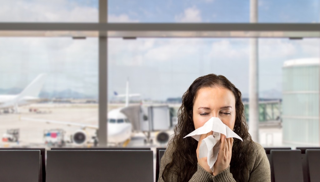 Woman sneezing at the airport.
