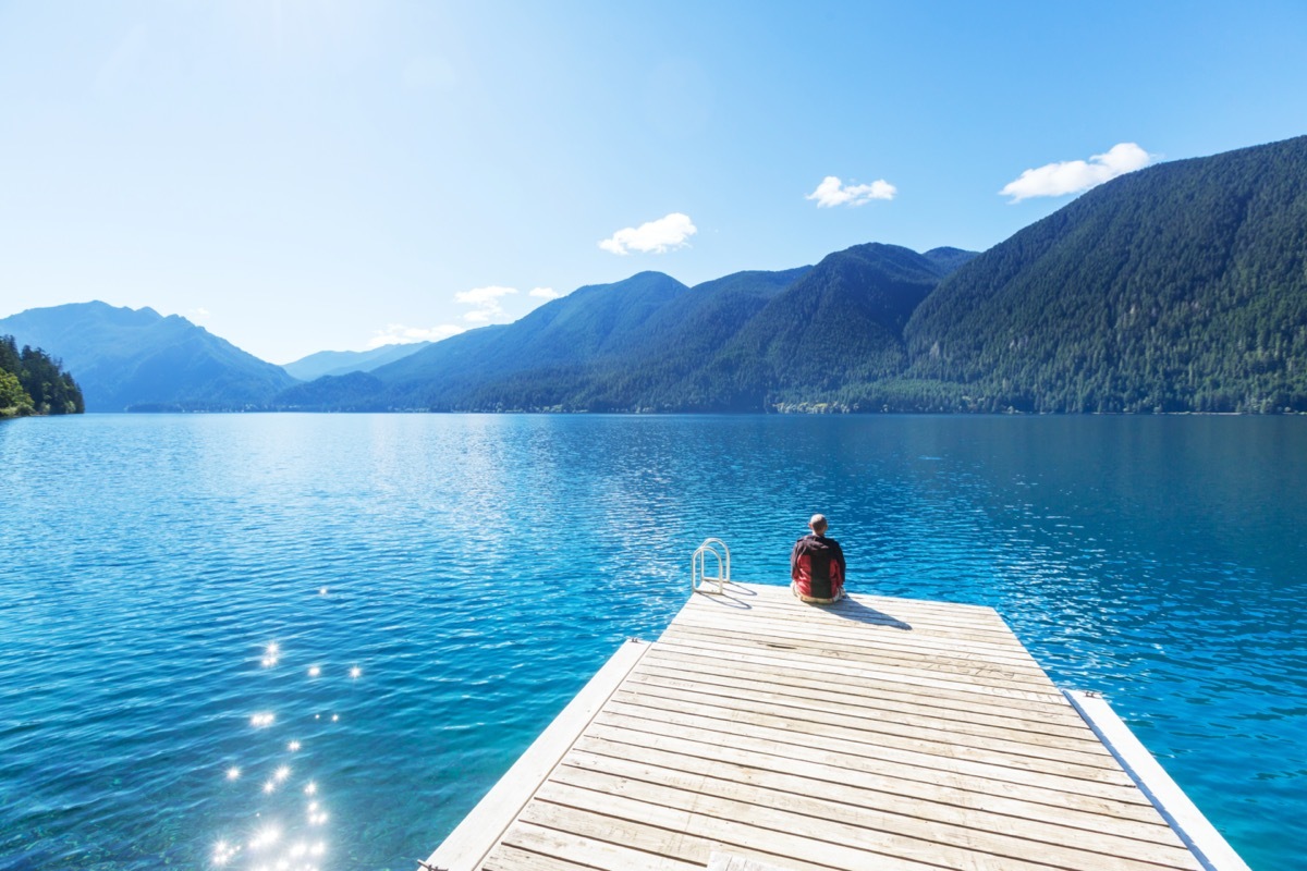 person sitting on a dock at lake crescent washington