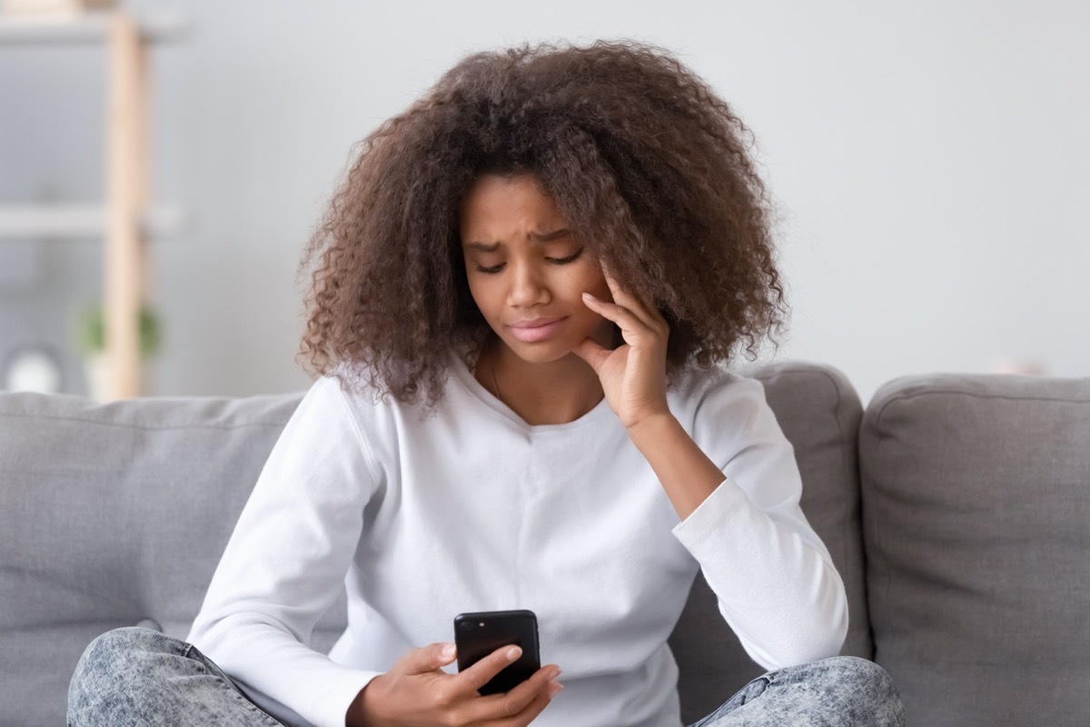 Woman upset looking at her texts.