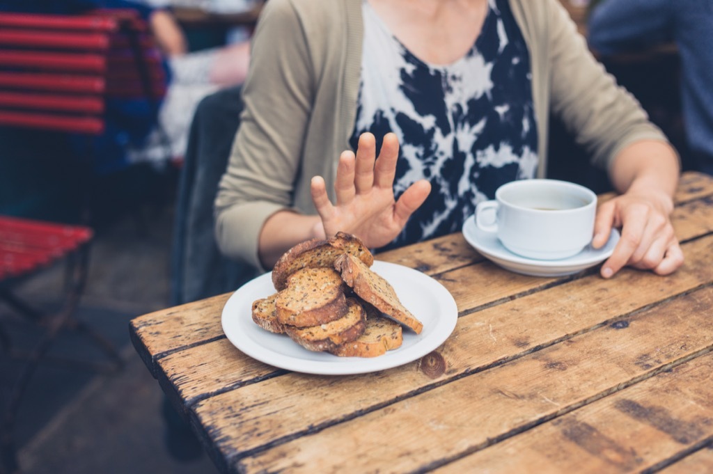 Woman pushing away bread plate