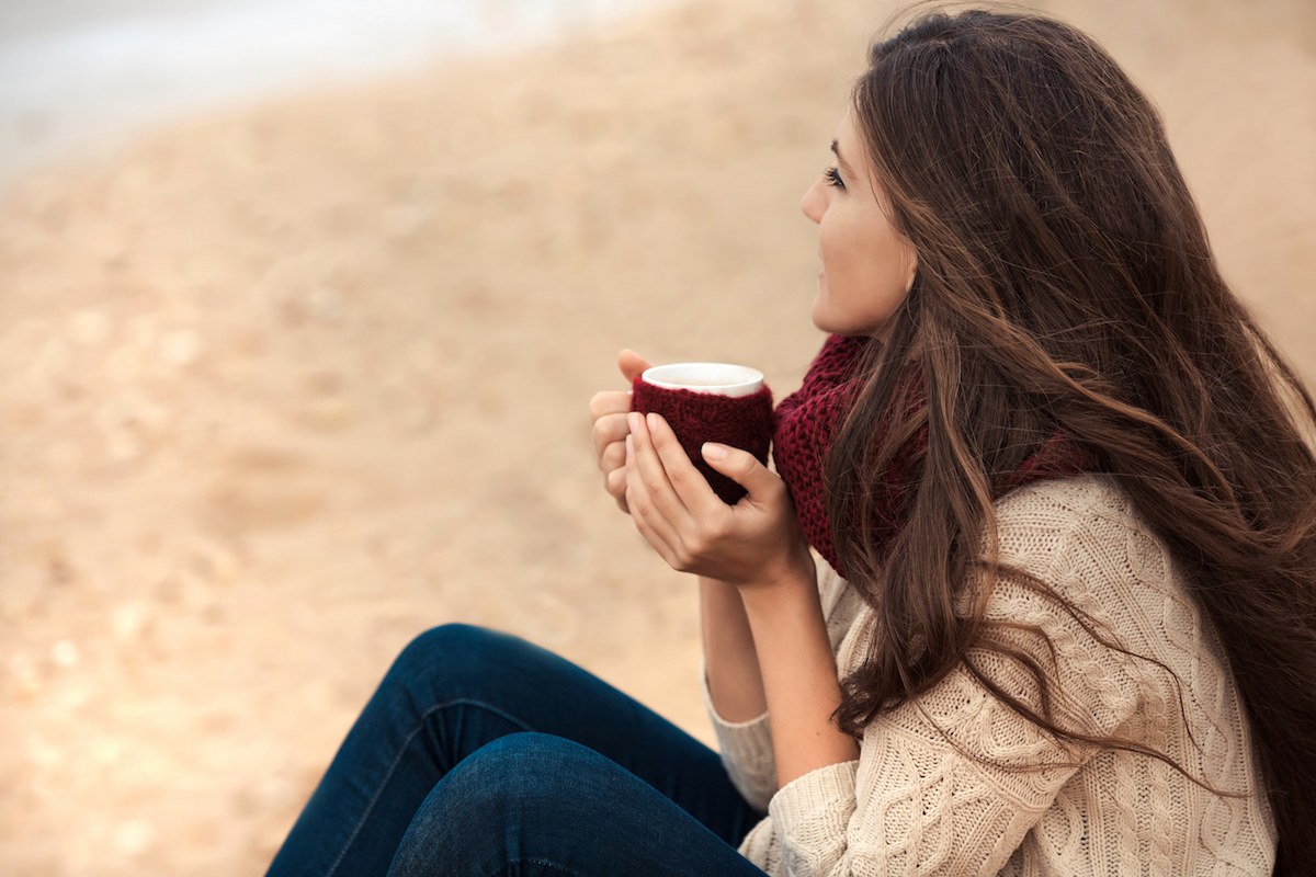 Woman drinking coffee on the beach christmas depression