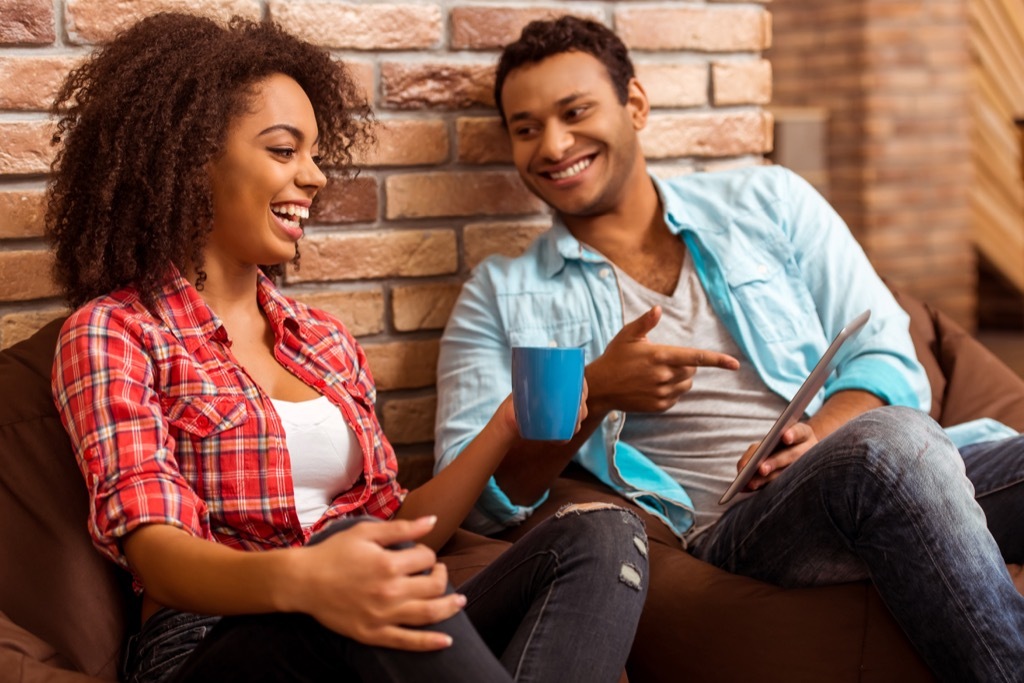 man and woman laughing and looking at a tablet, '60s slang