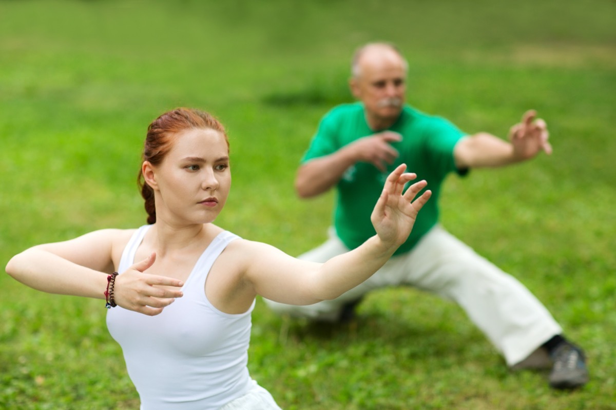 group of people practice Tai Chi Chuan in a park