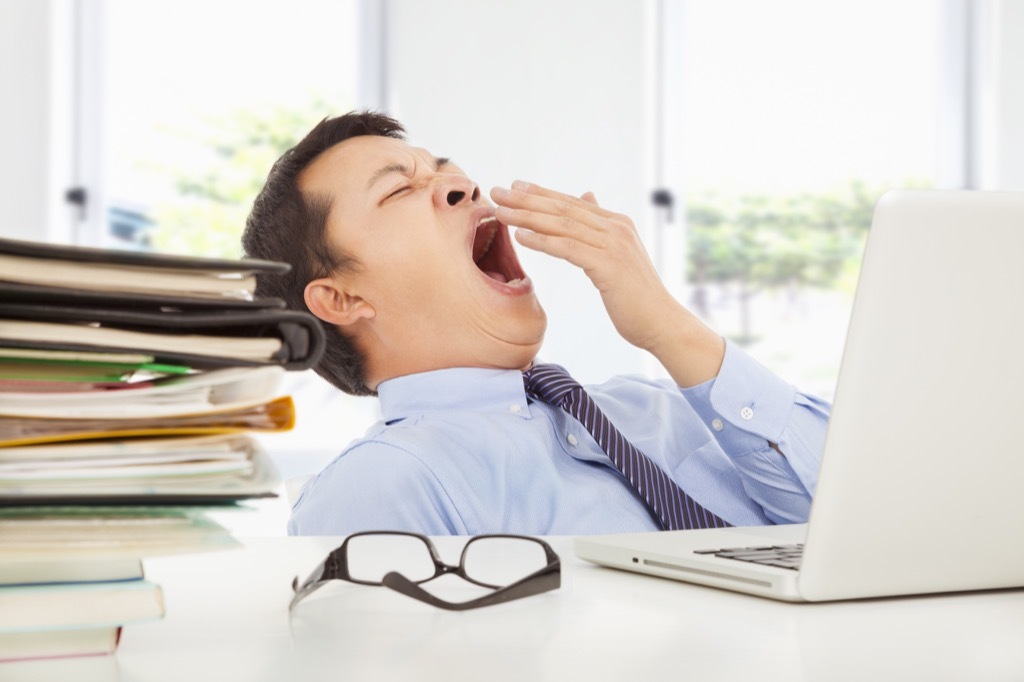 Man yawning at work.