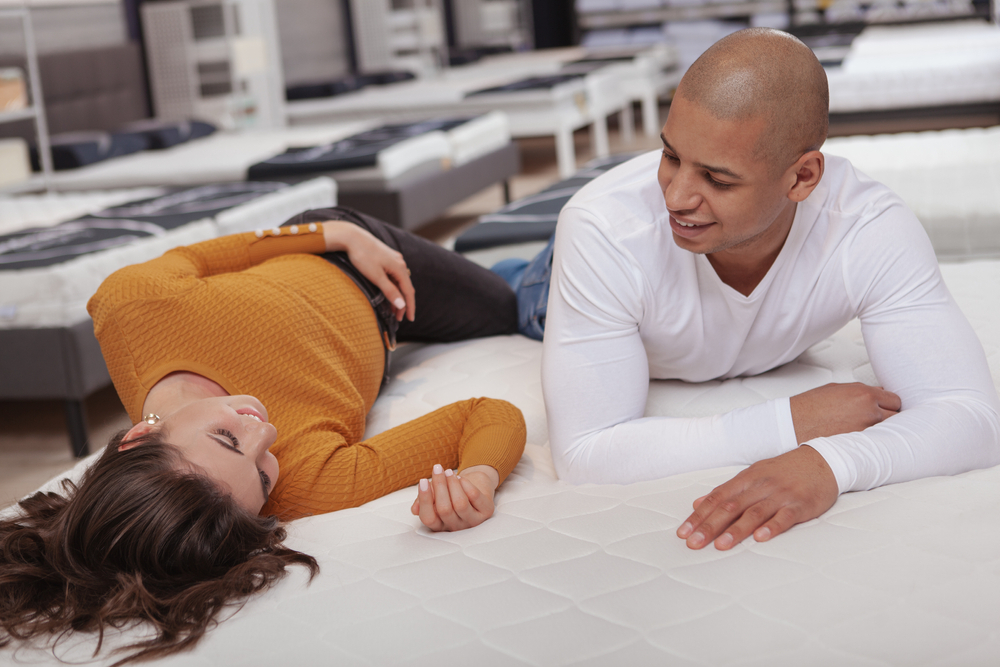 A couple testing out mattresses in a store