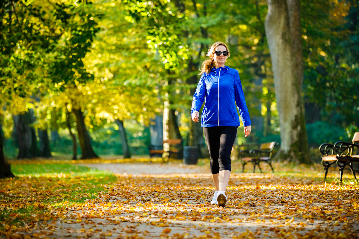Woman walking through a park.