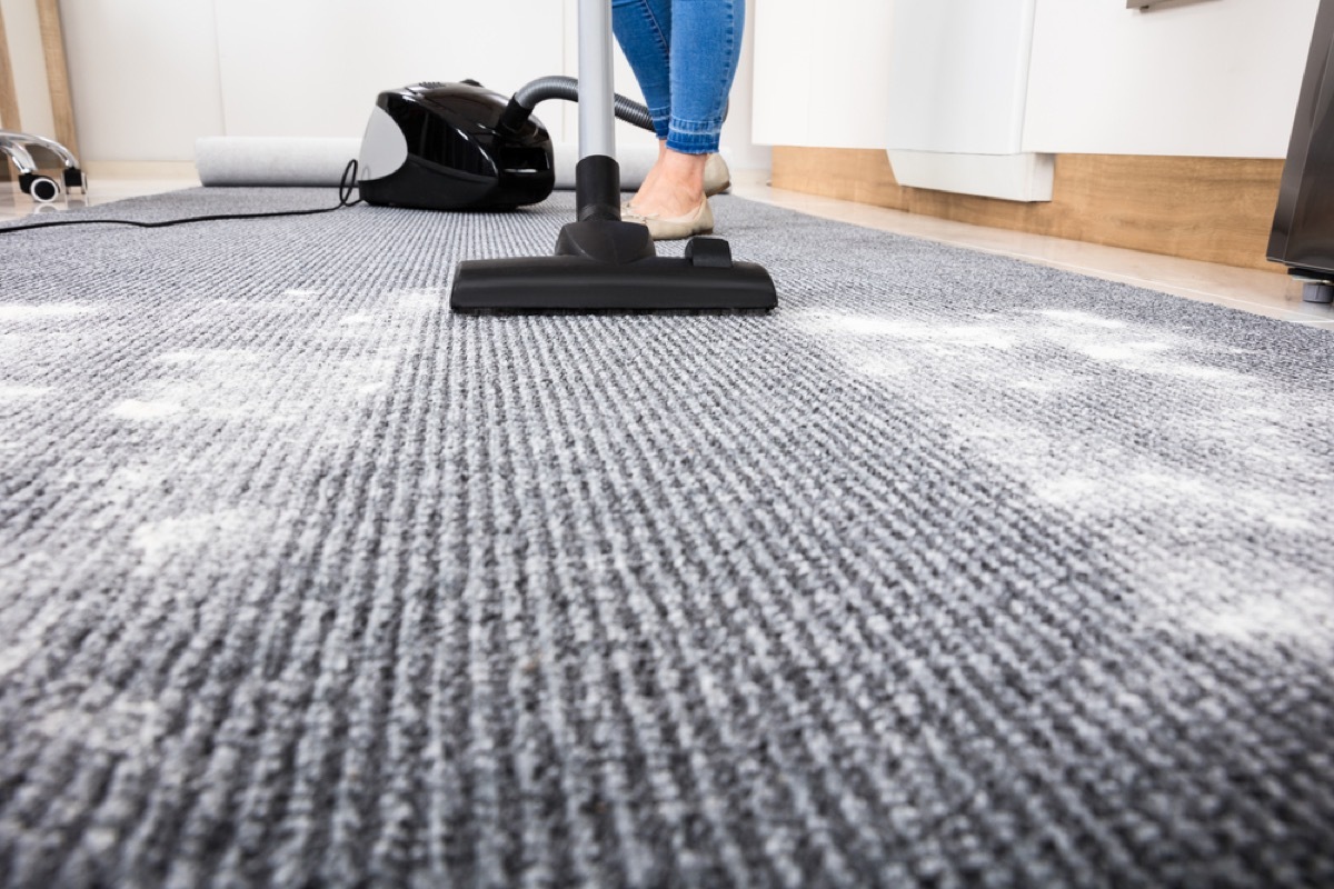 woman vacuuming up powder from carpet, easy home tips