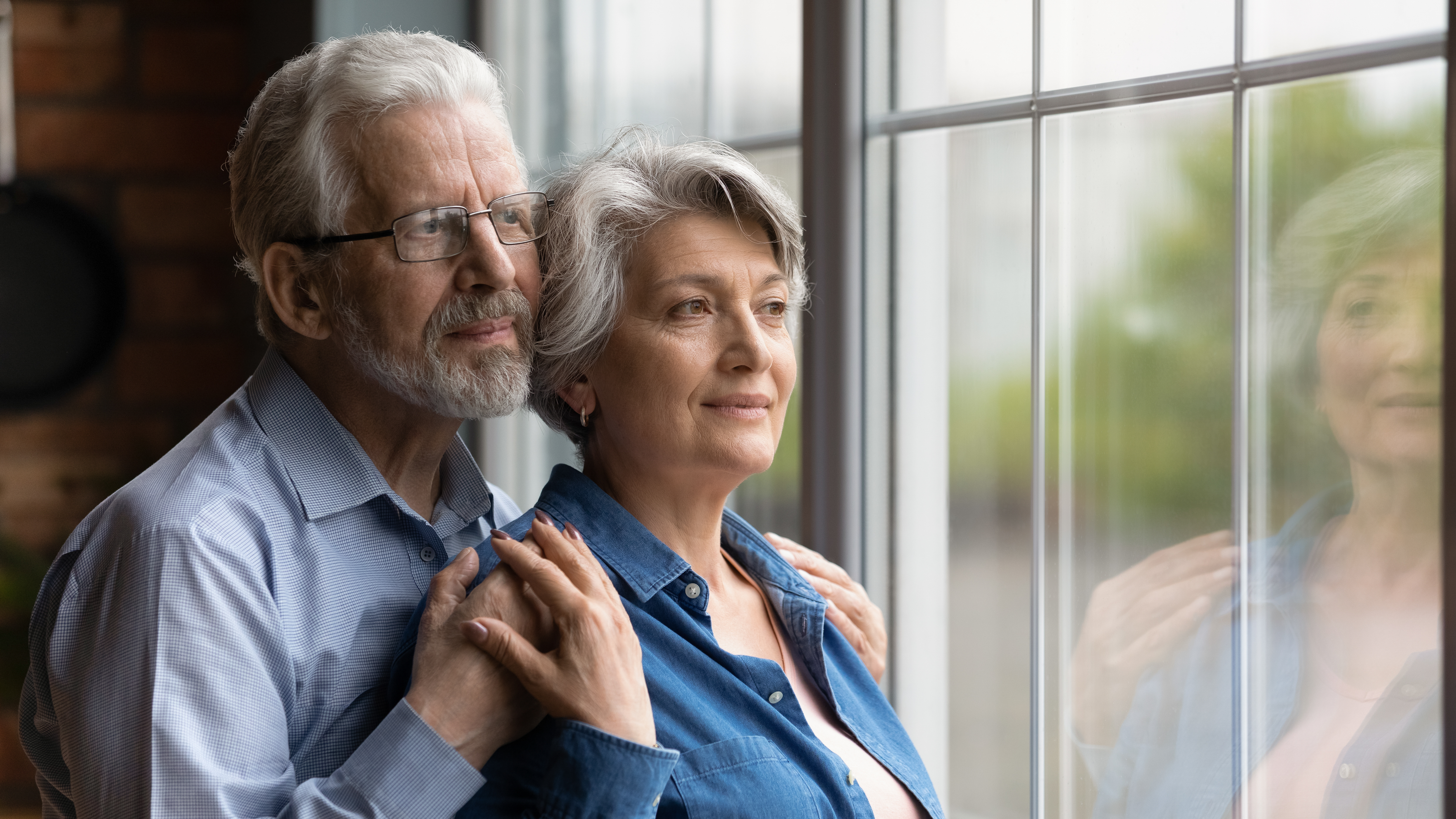 Senior couple looking out the window together