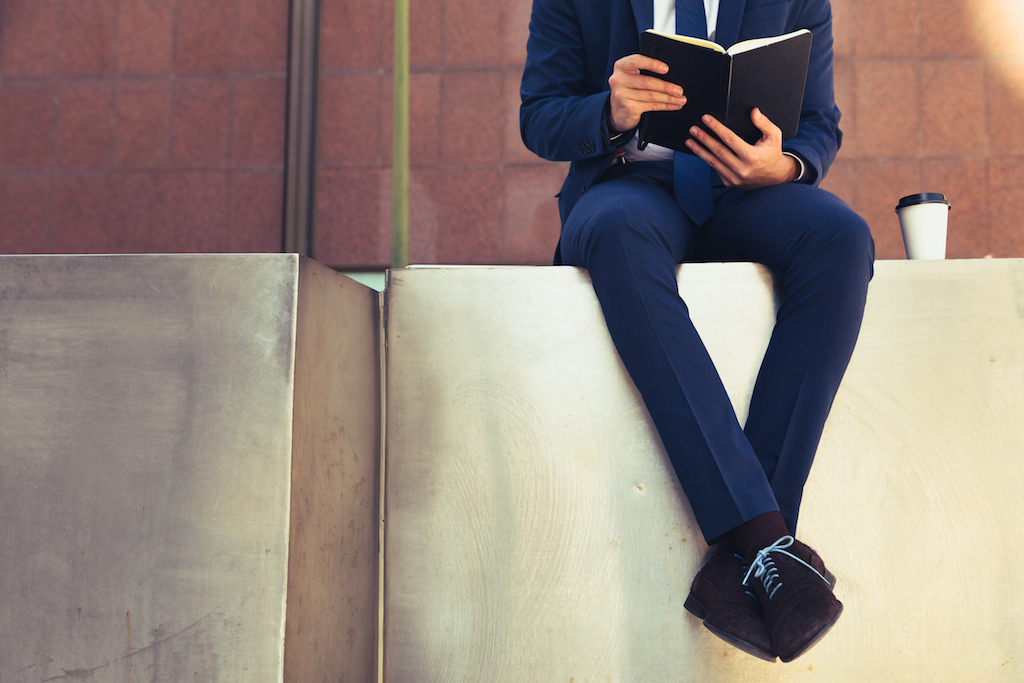 man reading a book in a suit, how to dress over 40