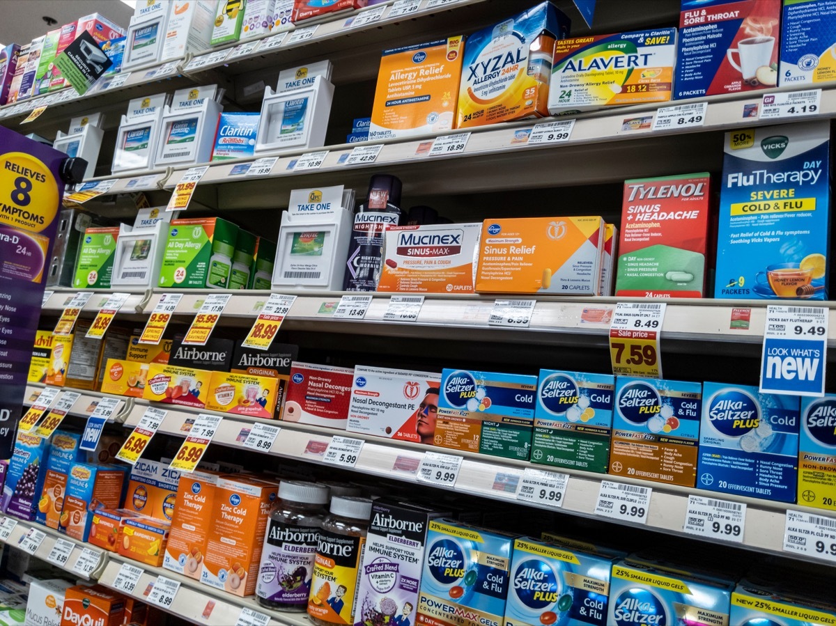 Angled view of the sinus relief and medication aisle inside a QFC grocery store.