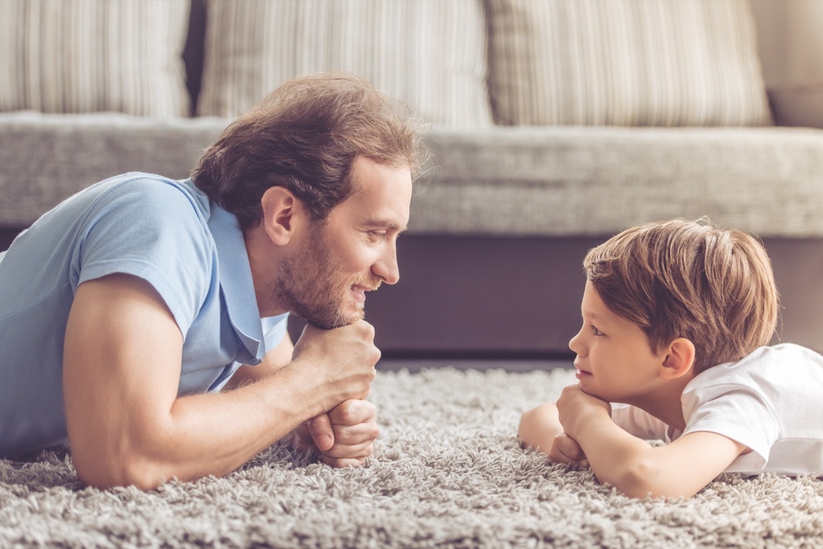 father and son laying on the floor facing each other