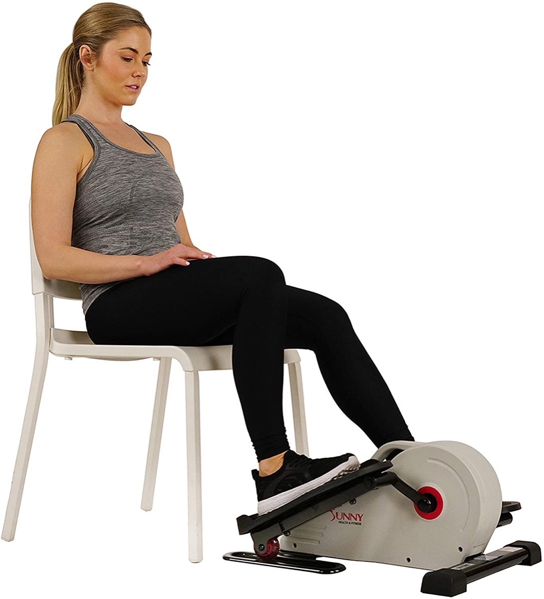 young blonde woman using under desk elliptical