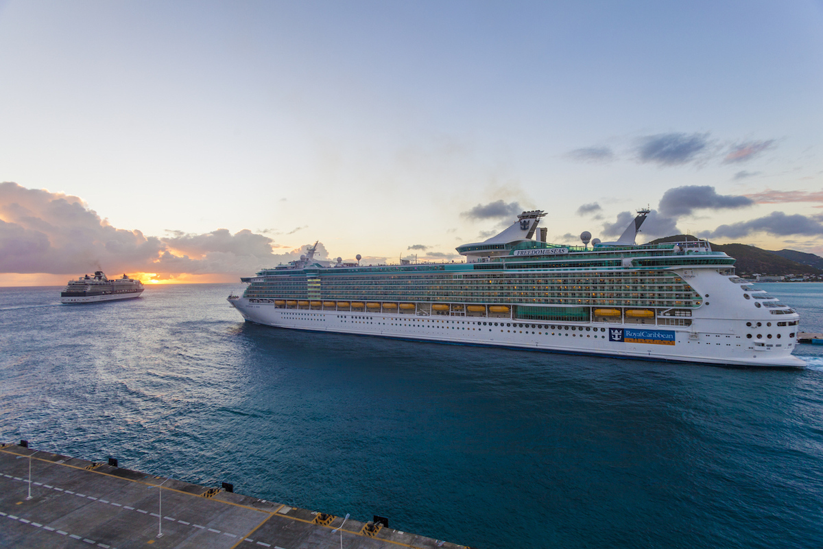 A Royal Caribbean cruise ship leaving port at dusk.