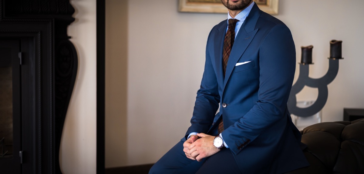 man sitting and wearing a buttoned suit