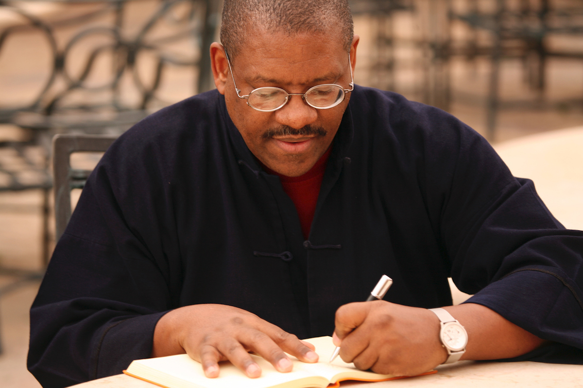 Left-handed man writing in notebook