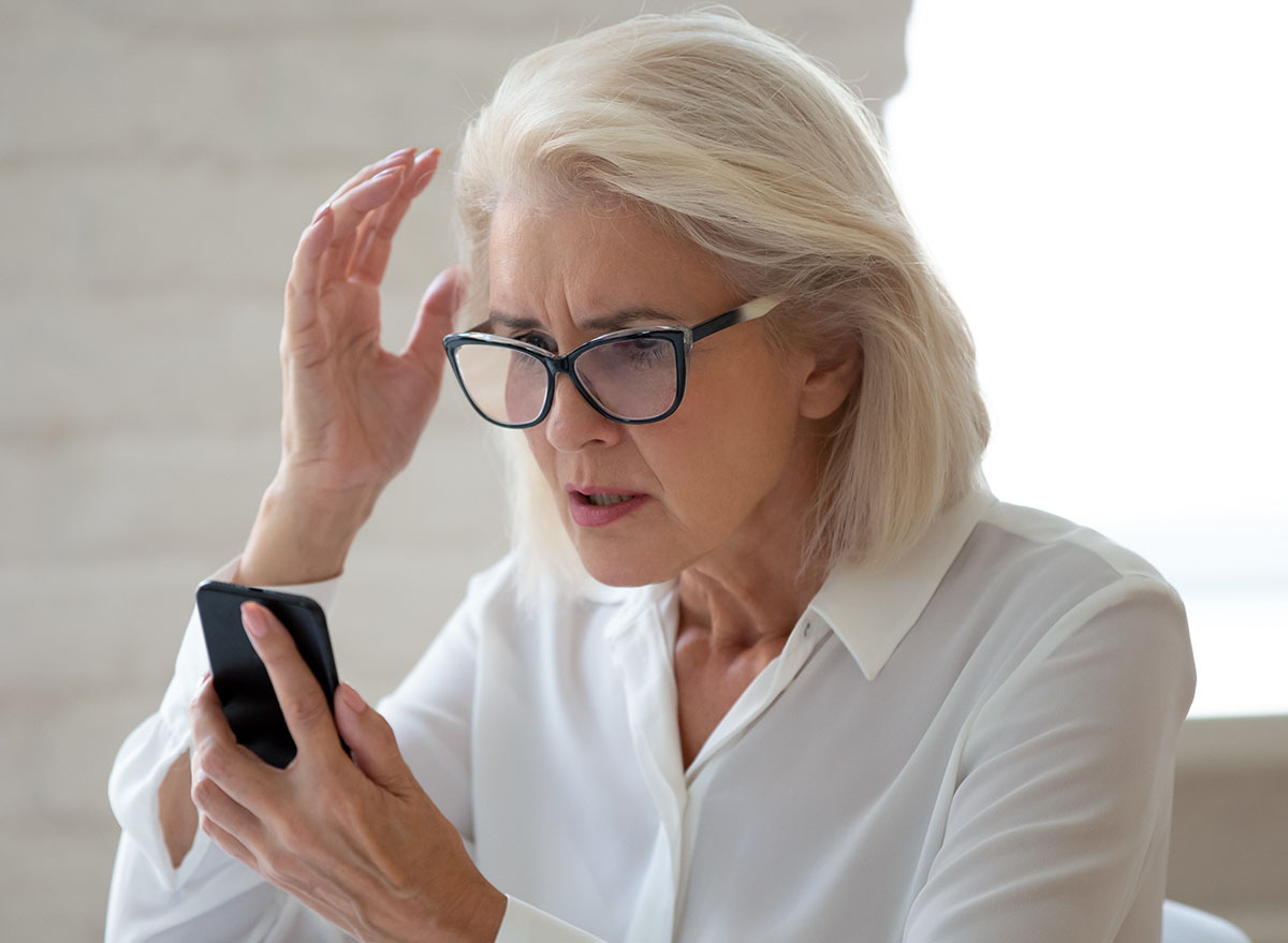 Woman looking at phone, aghast