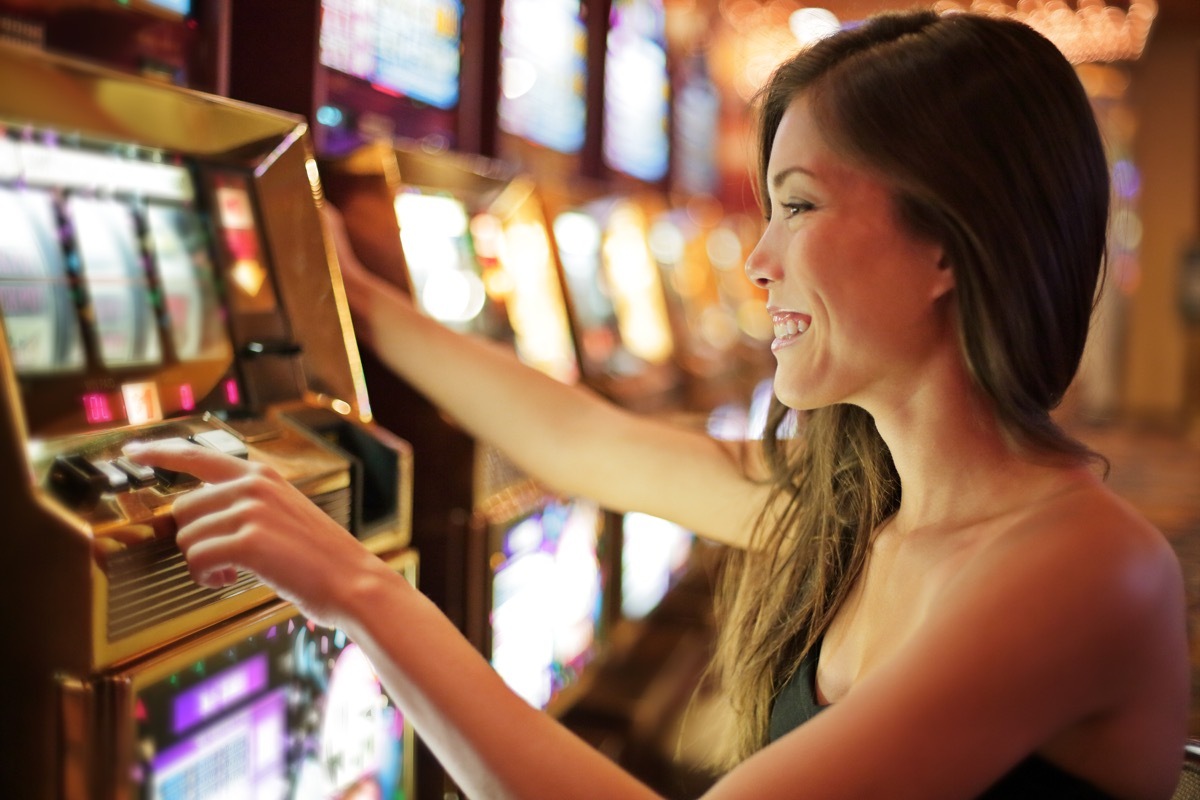 woman playing slot machines game cages worker