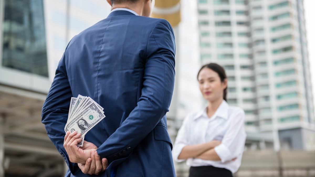 a man hiding his money from his girlfriend behind his back