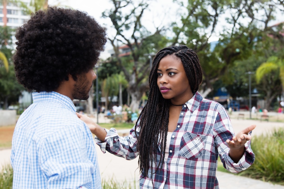 woman throwing up hands in annoyance at man