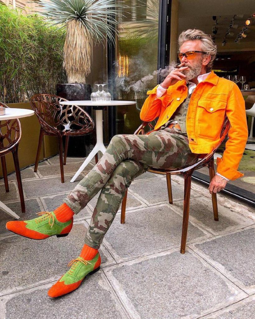 Pierrick makes work Bright orange jacket, tight camo pants, bright orange and green shoes | 12 Classiest Yet Fun OOTD You’ve Ever Seen From Pierrick Mathon | Her Beauty