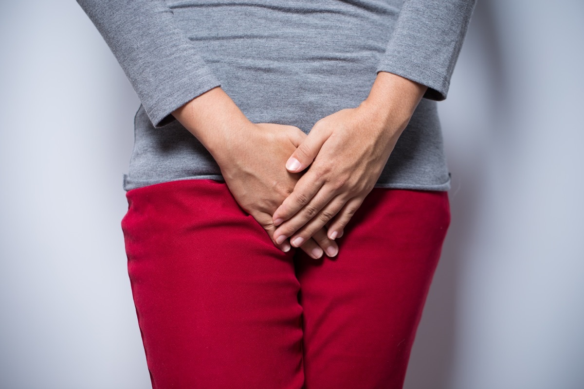 Woman with hands holding her crotch