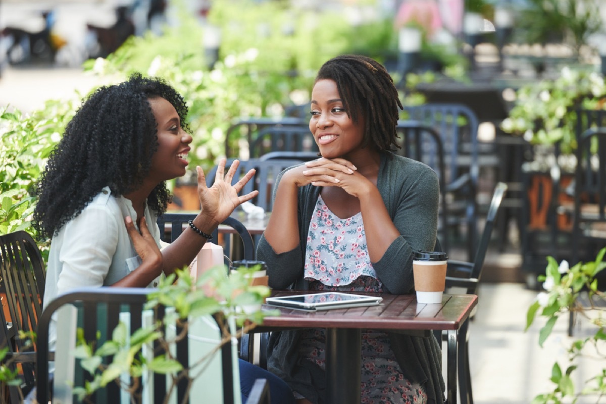 women talking in an outdoor courtyard, working mom