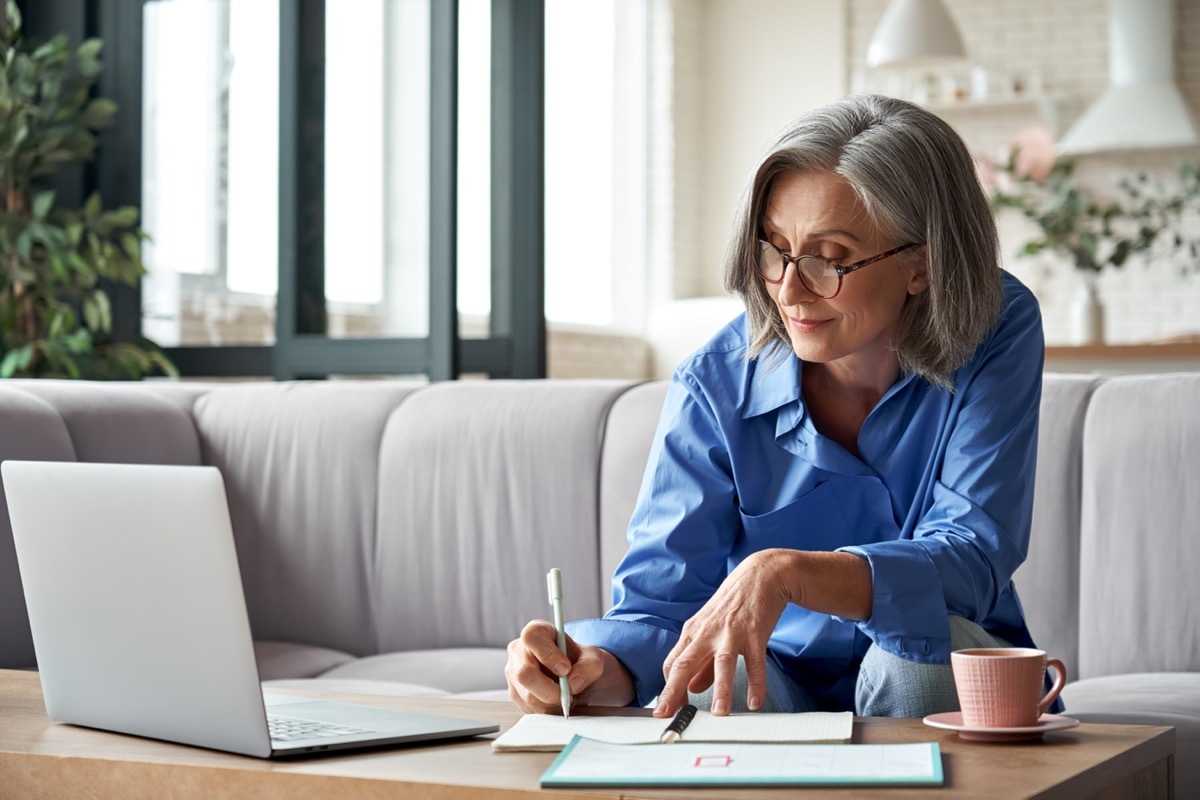 Woman on her couch working.