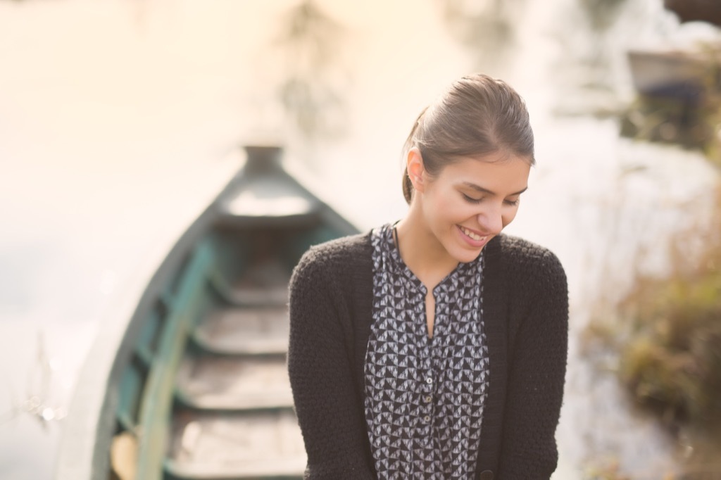 Beautiful woman smiling in a canoe, where she strips away stress
