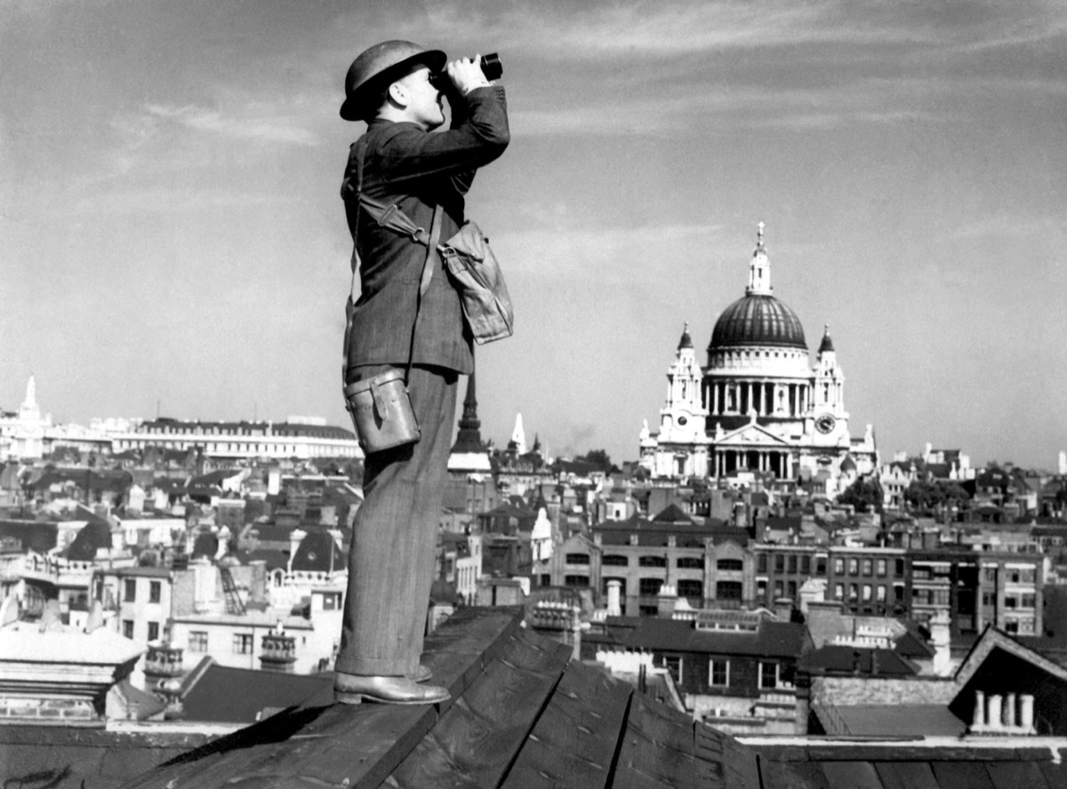 Aircraft spotter searches the sky with binoculars during the Battle of Britain. St. Paul's Cathedral is in the background. World War 2