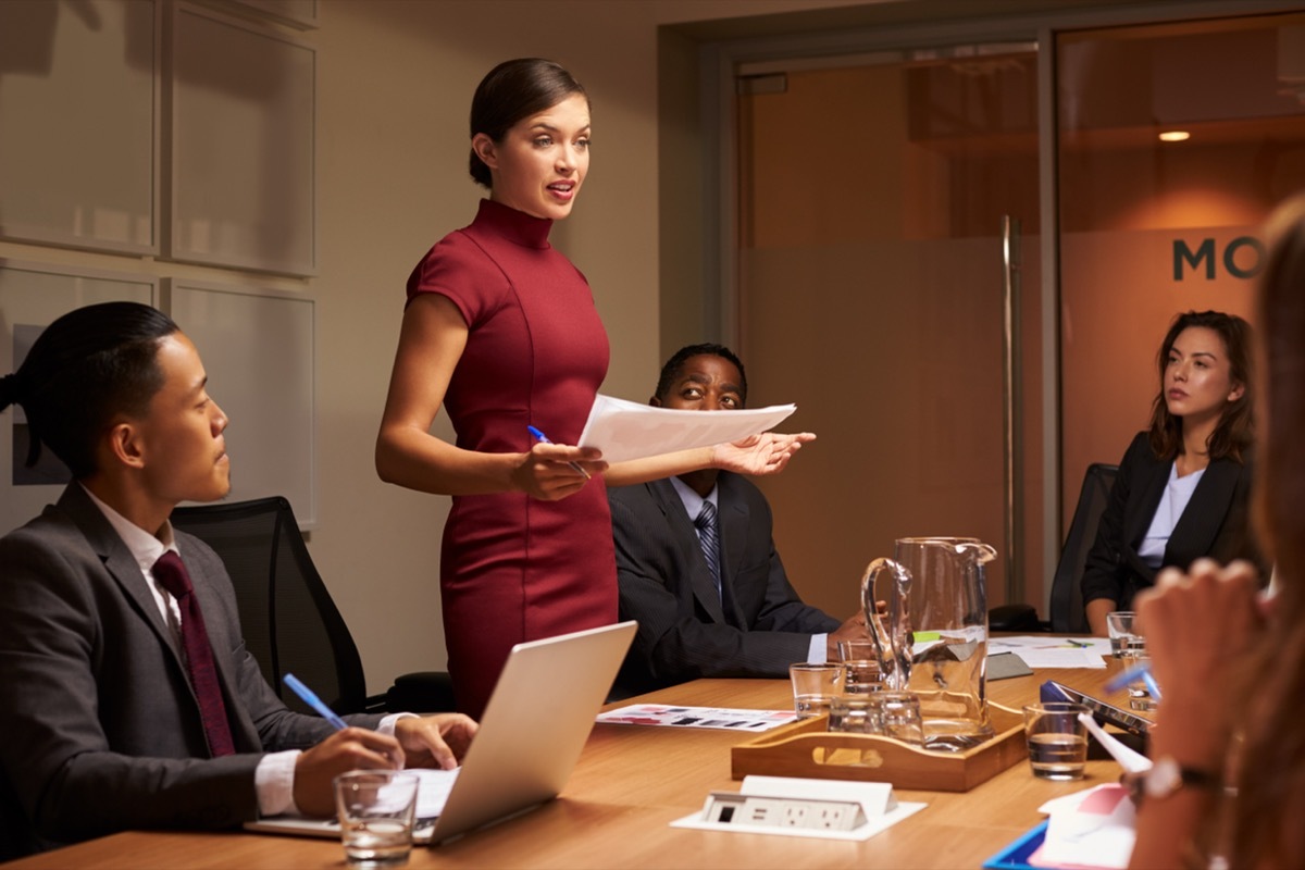 Boss working with her teammates wearing a red dress.