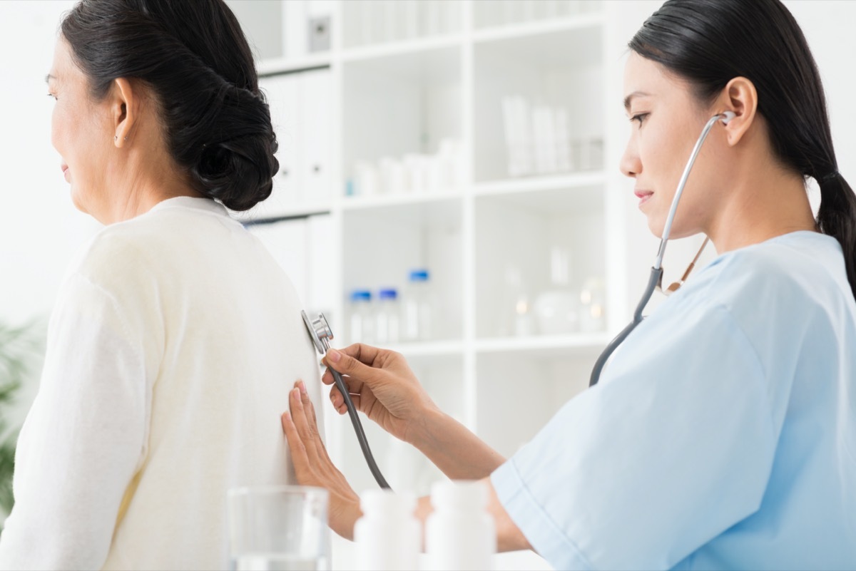 young asian female doctor listening to patient's breathing