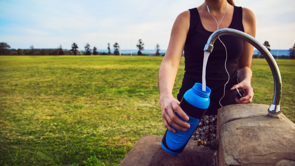 woman filling up water bottle
