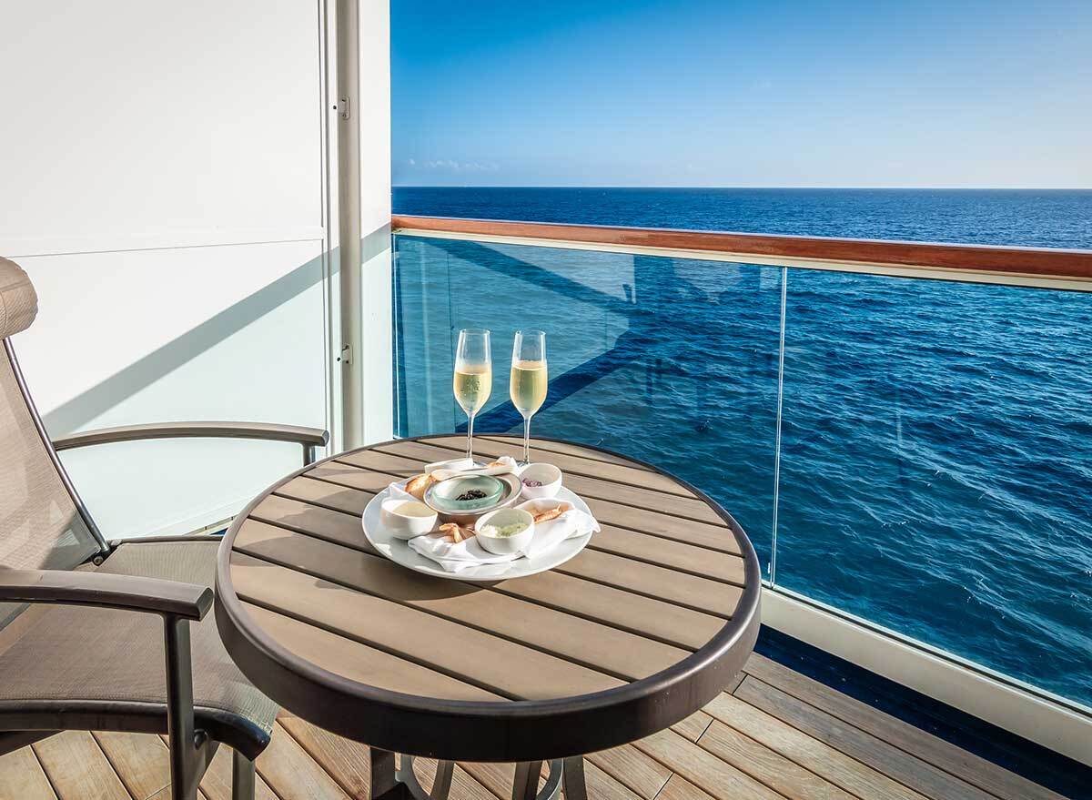 two glasses of champagne sit on a table on a cruise ship balcony