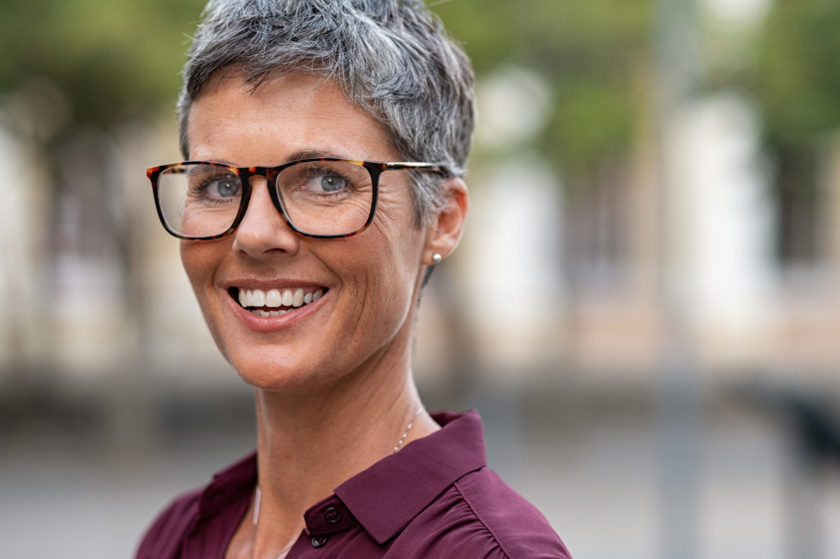 Portrait of businesswoman with gray hair wearing eyeglasses while looking at camera.