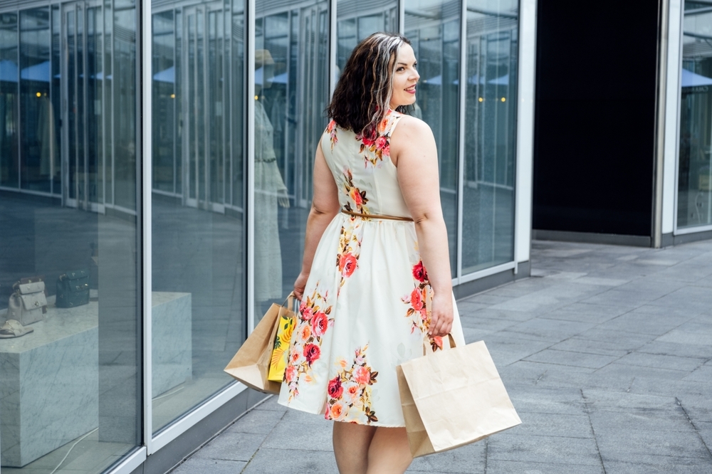 Curvy woman shopping with spring floral fit and flare belted dress